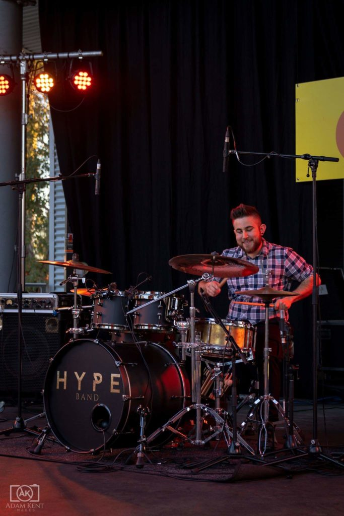Nick playing drums on stage with Hype Band